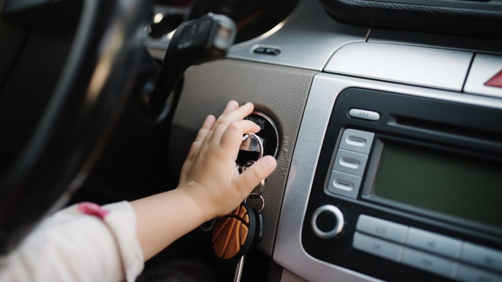 Mão girando a chave na ignição de um carro