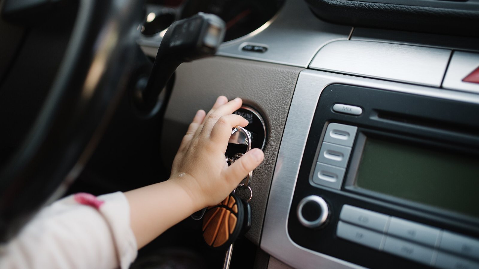 Mão girando a chave na ignição de um carro